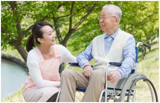 caregiver assisting elder man sitting on the wheelchair