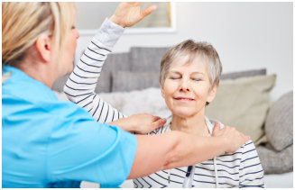 caregiver doing massage on elder woman